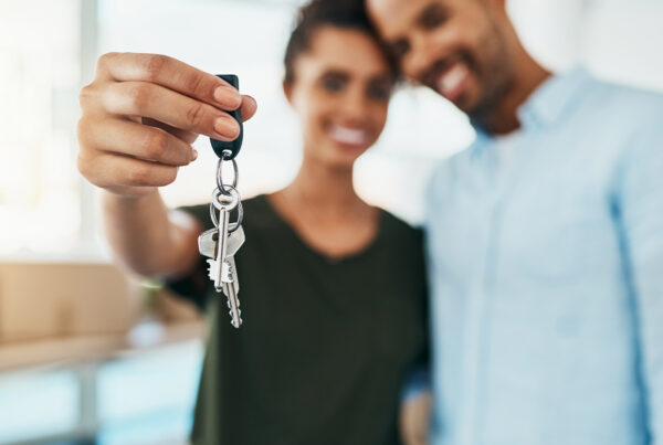 Couple holding house keys happily.